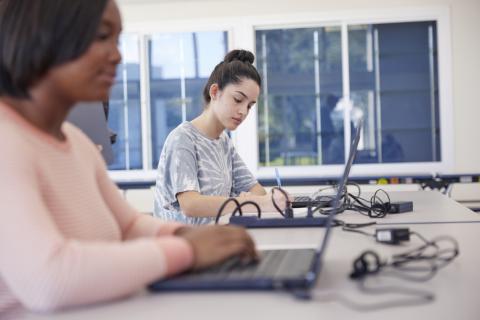 2 female students on laptops